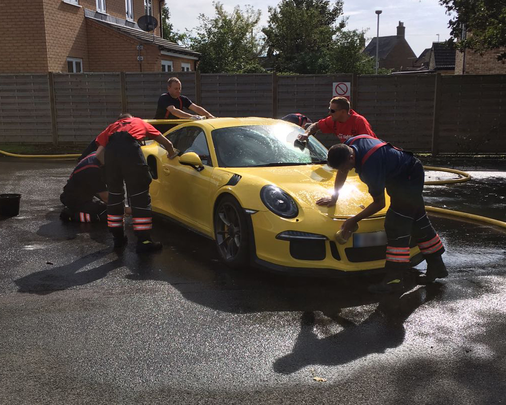Firefighters washing a car