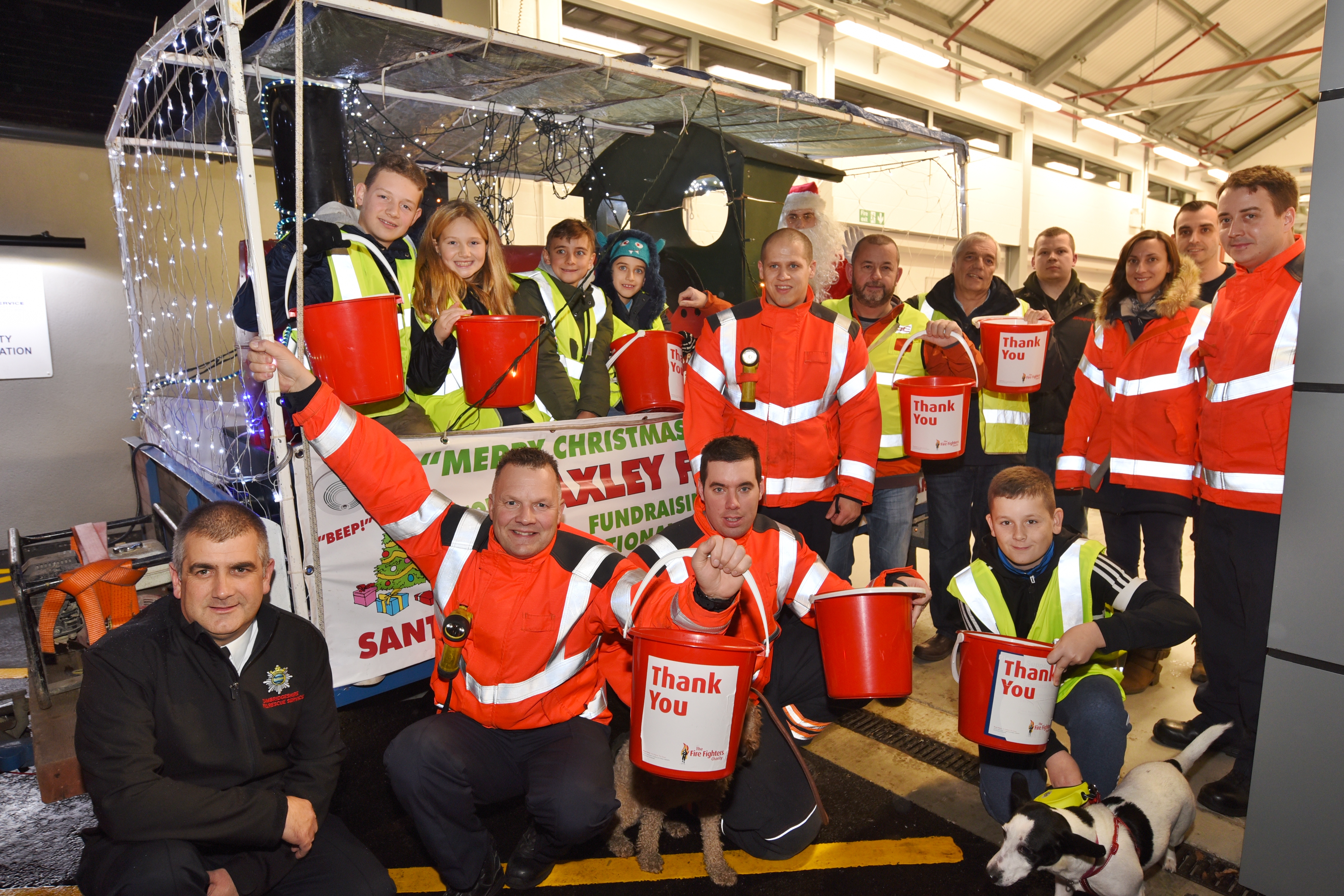 Firefighters pose in front of Christmas ride