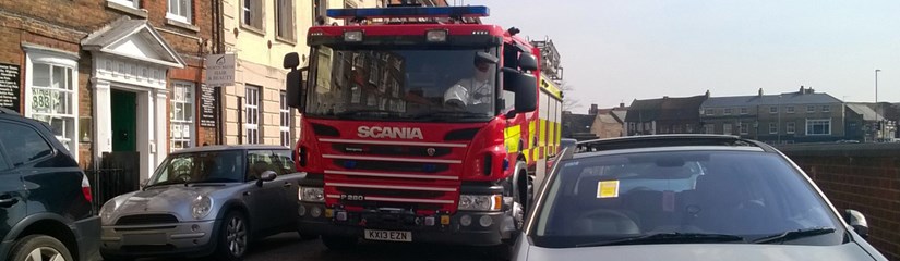 fire engine driving through road with inconsiderate parking