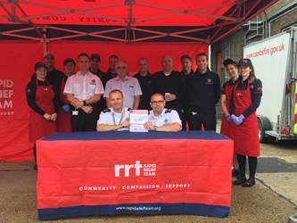 Firefighters kneeling at desk with agreement with rapid relief team