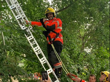 Firefighter rescuing a cat from a tree in Sawston