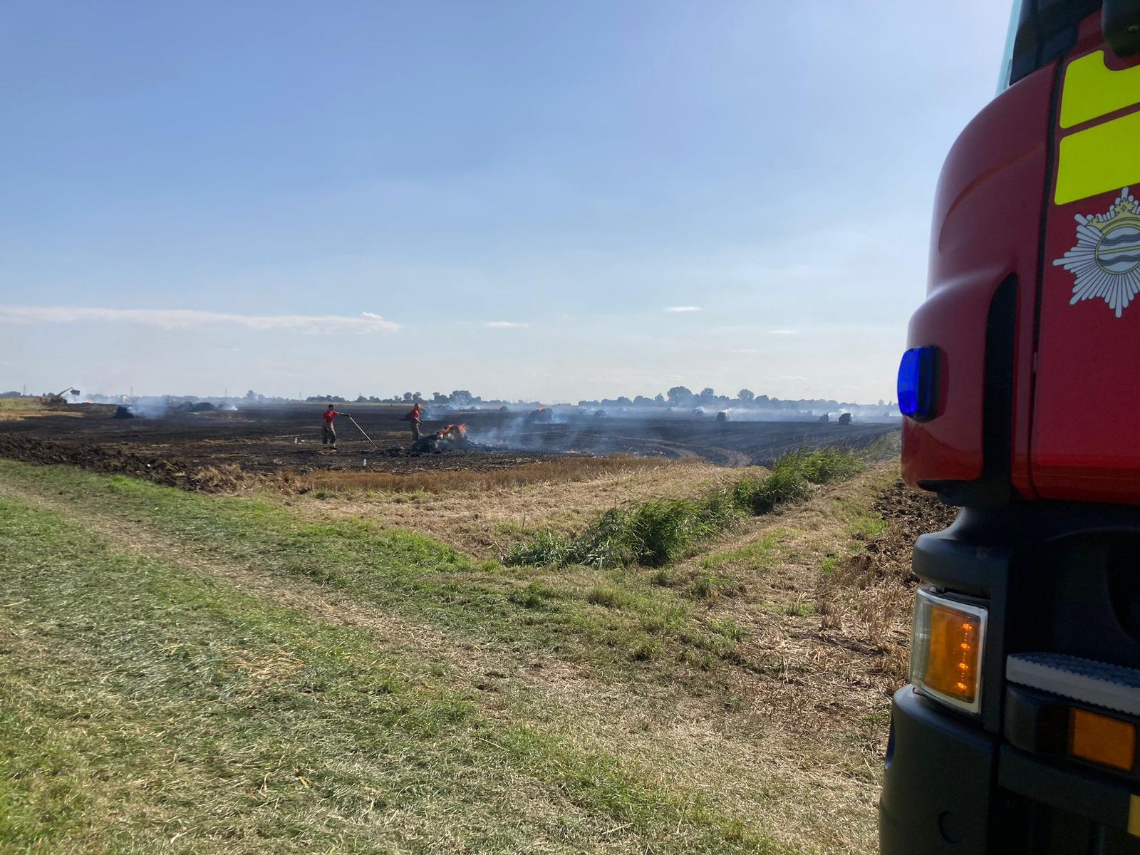 Firefighters tackling a fire in a field.
