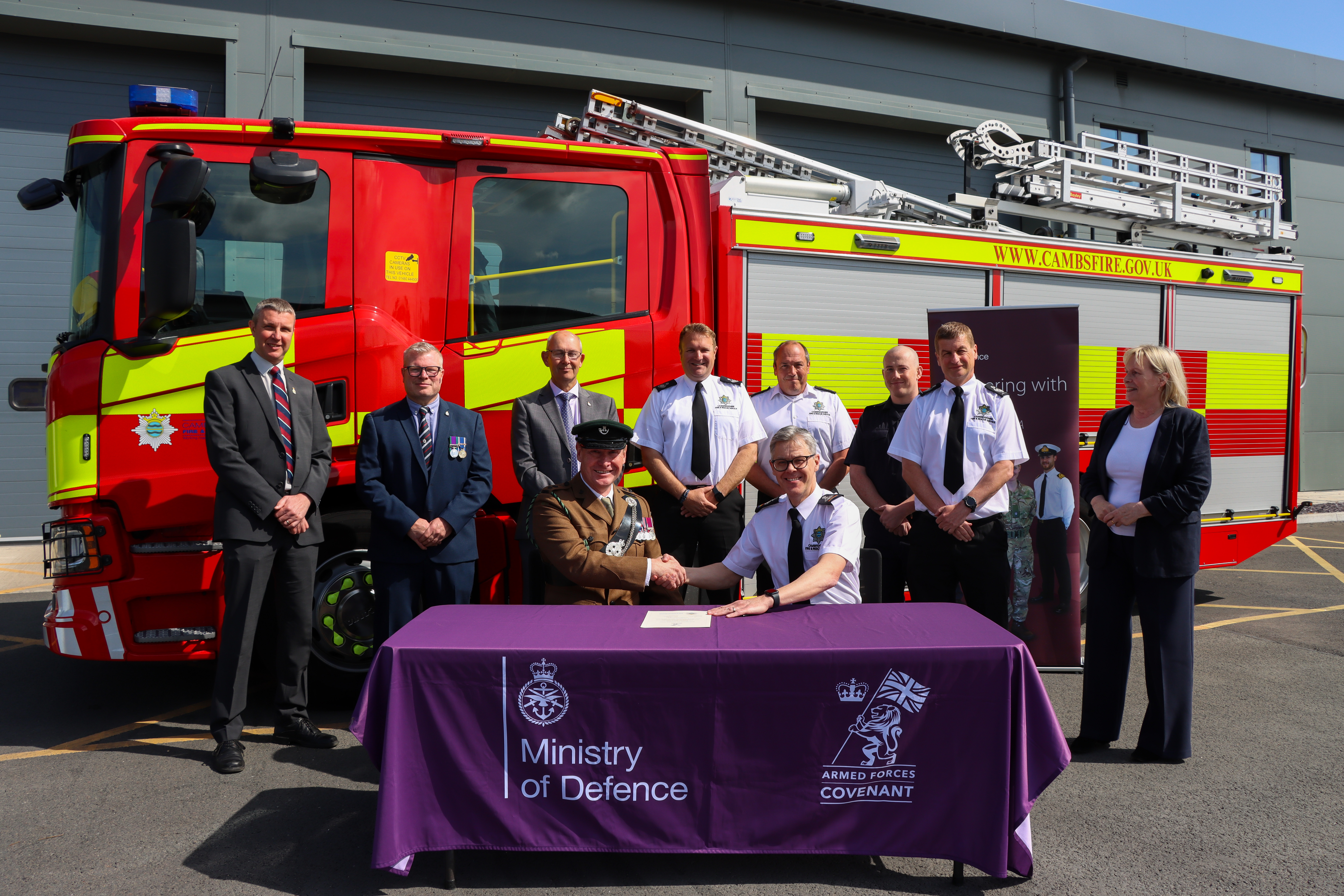Chief Fire Officer Matthew Warren (front right) signing AFC with Lt Col Matt Helsby - Commanding Officer of Cambridge University Officer Training Corps. They were joined by (from left to right) Assistant Director John Fagg, Tommy Kelly - Armed Forces Covenant Partnership Coordinator – Cambridgeshire and Peterborough, Councillor Jon Neish - Armed Forces Covenant Partnership – Cambridgeshire and Peterborough, Assistant Chief Fire Officer Stuart Smith, Firefighters from Blue Watch Huntingdon, Deputy Chief Fire Officer Jon Anderson and Kristina Carrington - Regional Employer Engagement Director, EA RFCA (East Anglia Reserve Forces and Cadets Association), MOD.